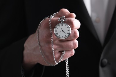 Photo of Man holding chain with elegant pocket watch, closeup