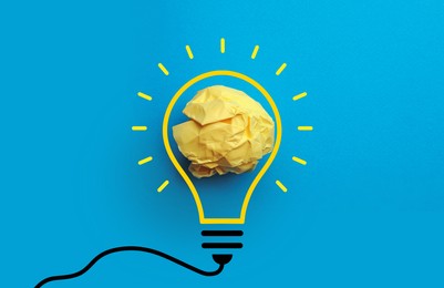 Idea. Illustration of light bulb around crumpled paper ball on light blue background, top view