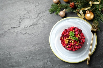 Traditional Russian salad vinaigrette and Christmas decorations on grey table, flat lay. Space for text