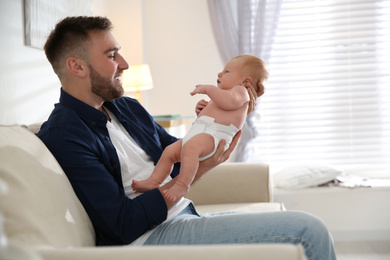 Photo of Father with his newborn son at home