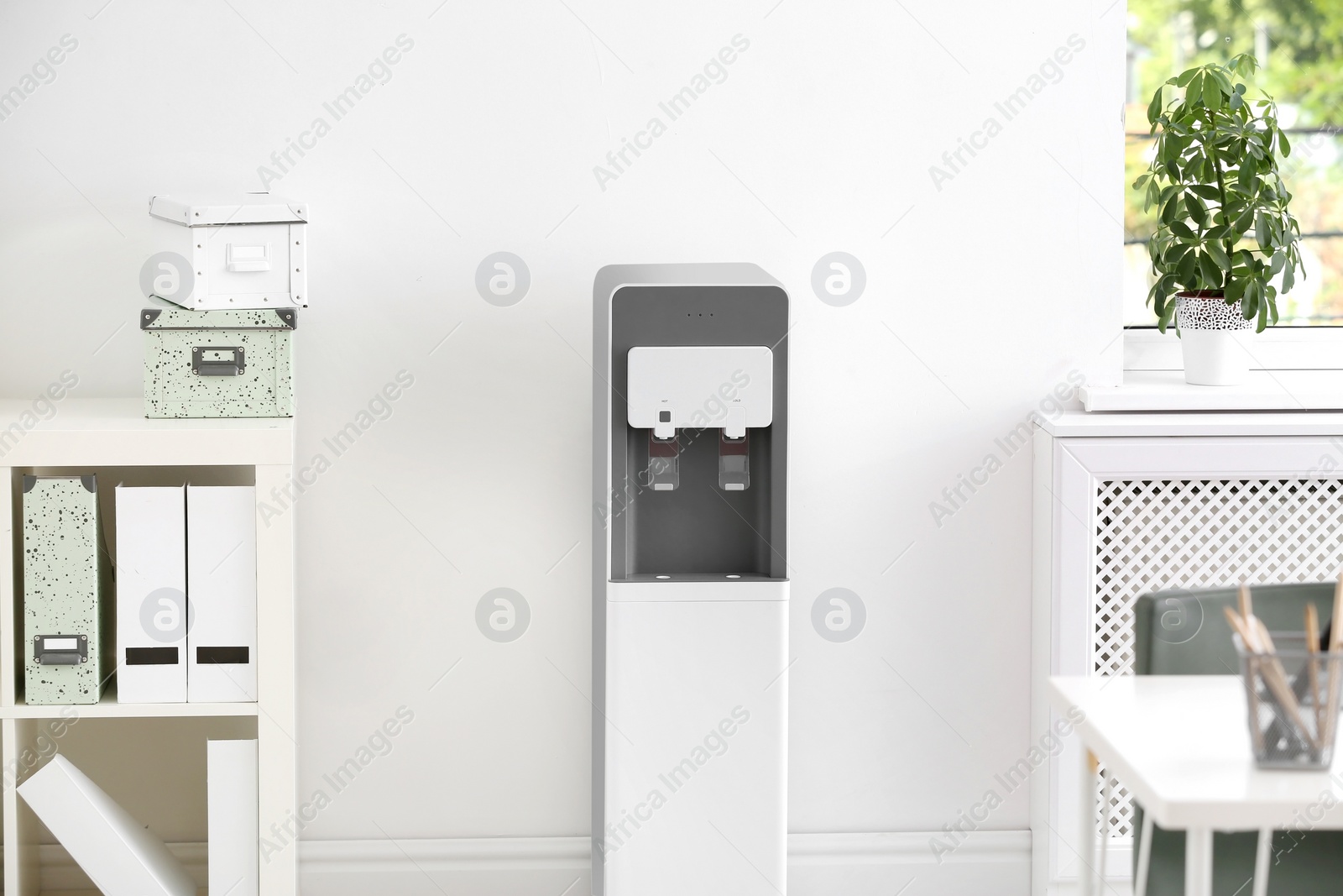 Photo of Modern water cooler in stylish office interior