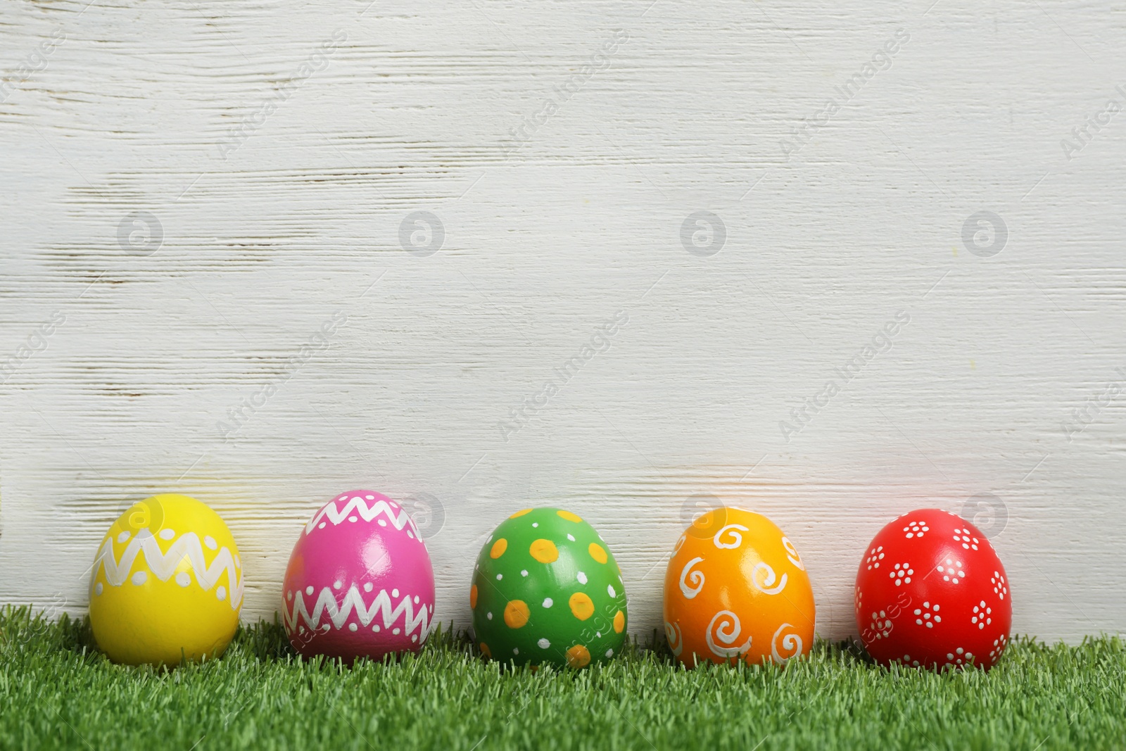 Photo of Decorated Easter eggs on green grass. Space for text