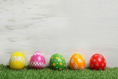 Decorated Easter eggs on green grass. Space for text