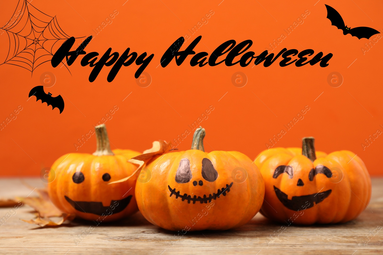 Image of Happy Halloween. Pumpkins with scary faces and fallen leaves on orange background