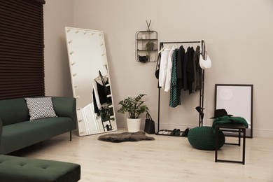 Photo of Modern dressing room interior with clothing rack and mirror