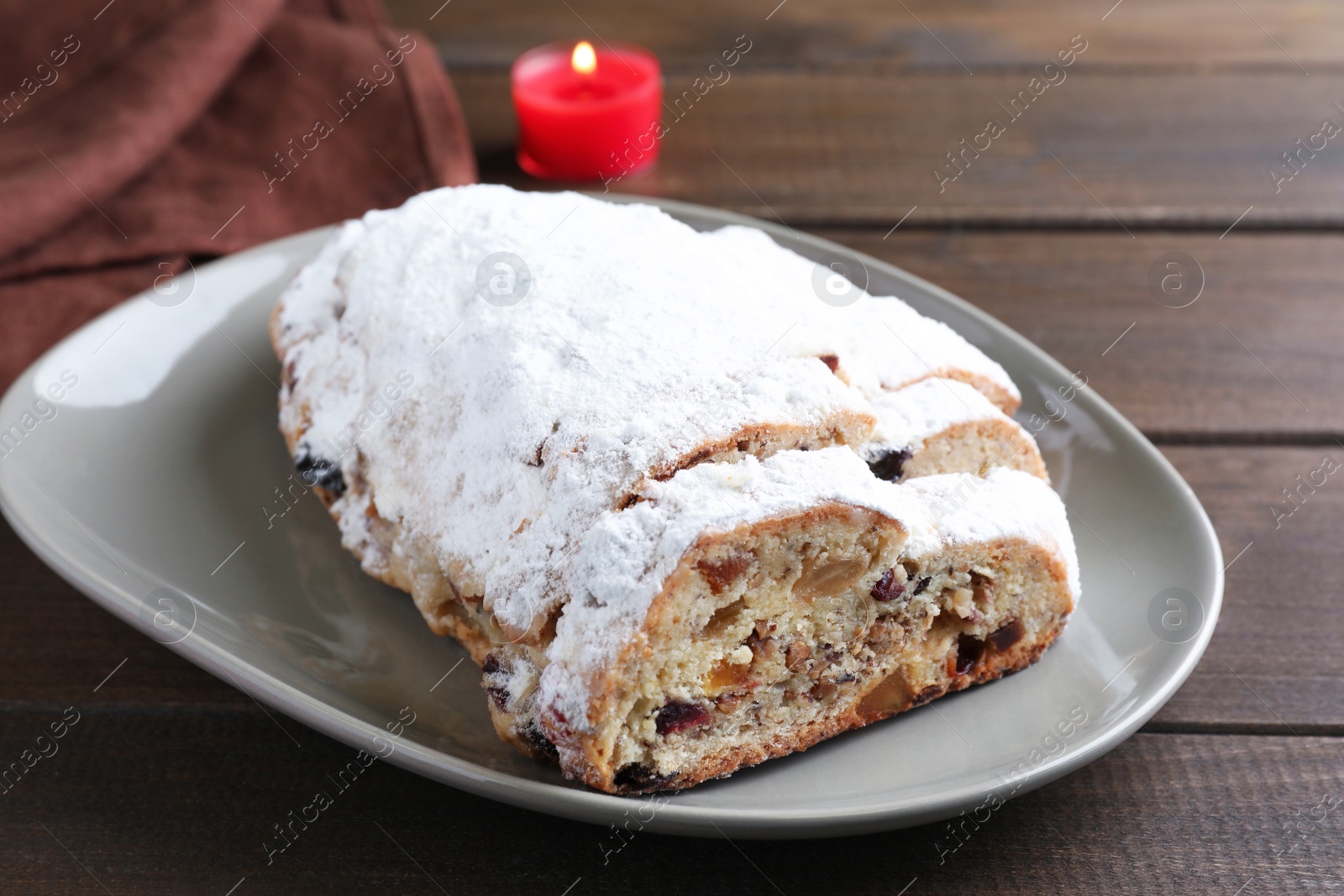 Photo of Traditional Christmas Stollen with icing sugar on wooden table