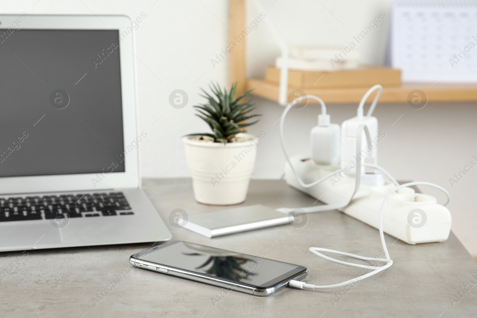 Photo of Devices charging with cable on light stone table