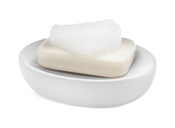 Photo of Soap bar with fluffy foam in holder on white background