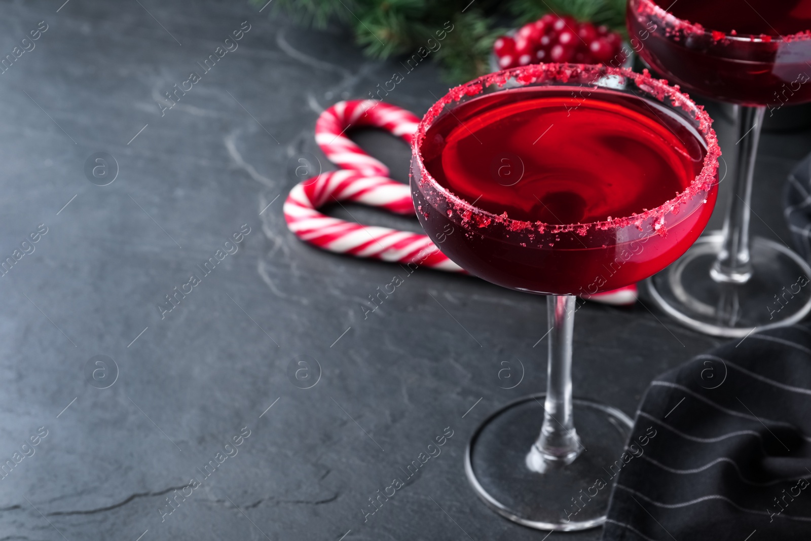 Photo of Delicious Christmas cocktail with liqueur on black table. Space for text