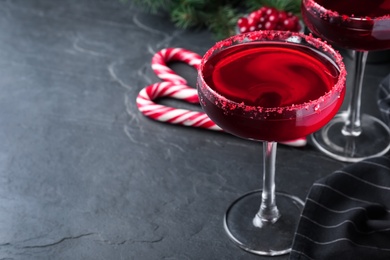 Photo of Delicious Christmas cocktail with liqueur on black table. Space for text
