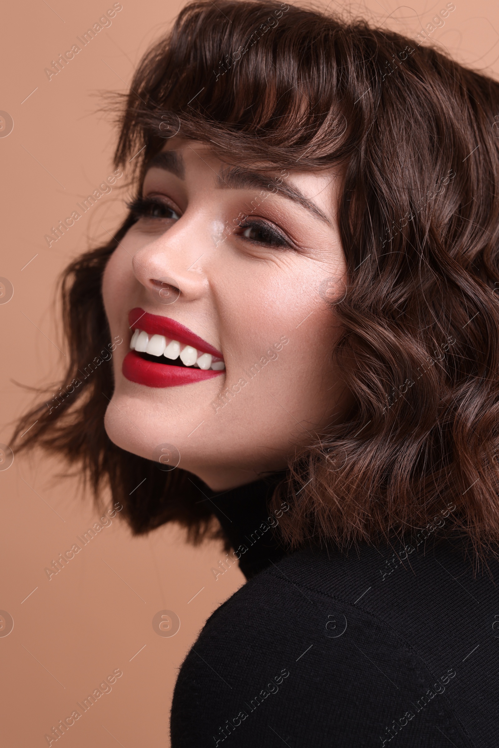 Photo of Beautiful young woman with wavy hairstyle on beige background