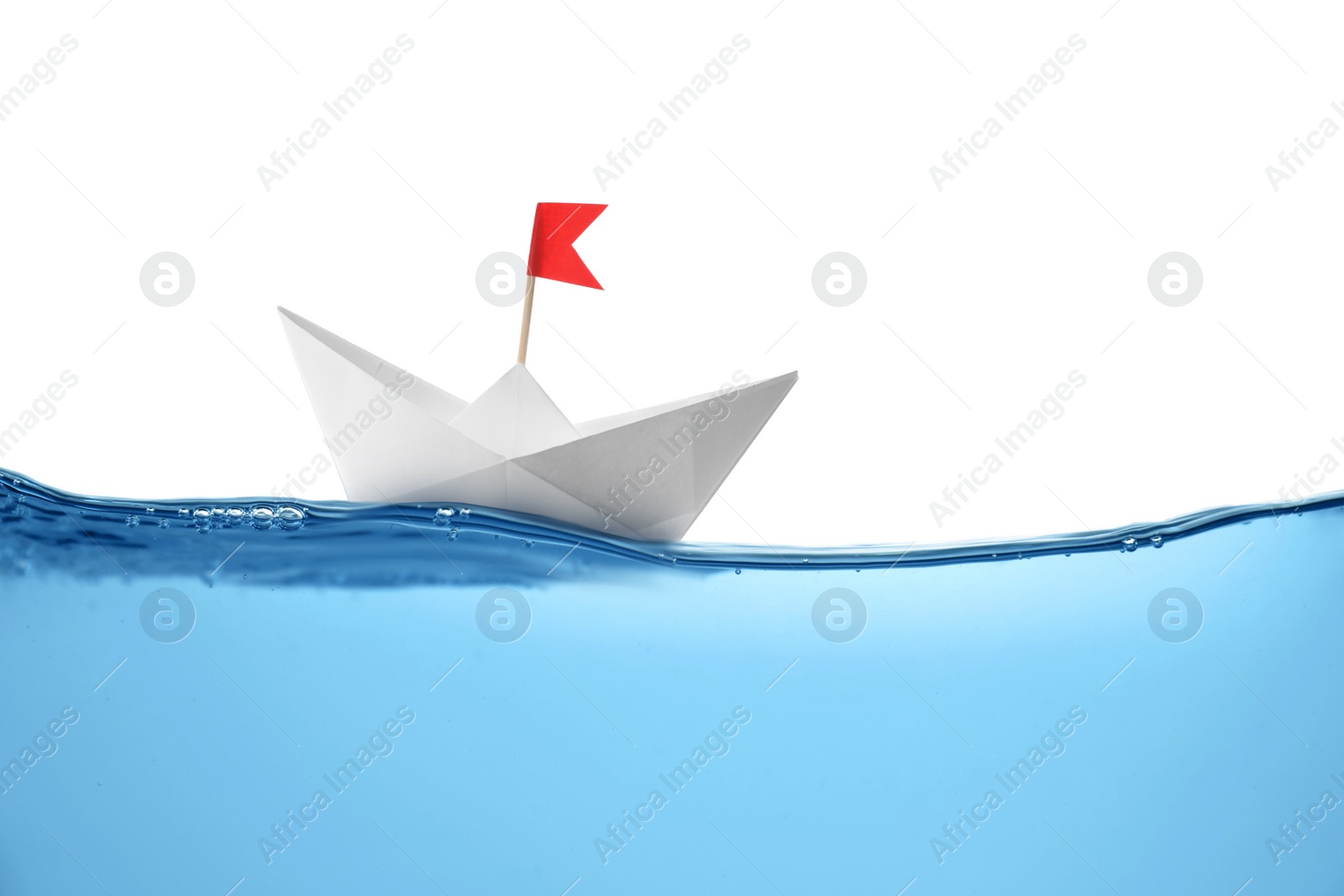 Image of Handmade paper boat floating on clear water against white background 