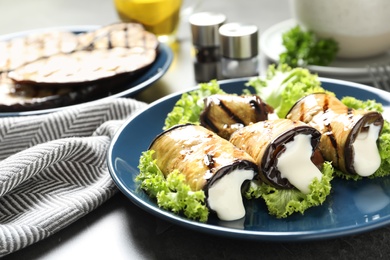 Plate with fried eggplant rolls on table, closeup