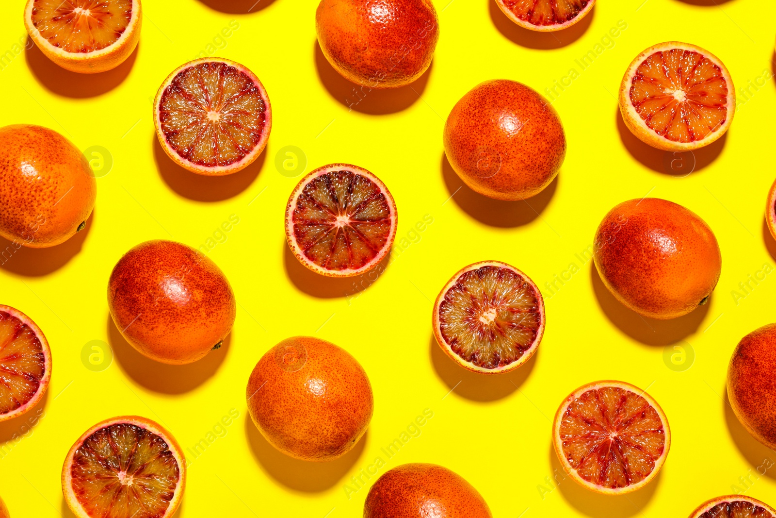 Photo of Many ripe sicilian oranges on yellow background, flat lay