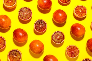 Many ripe sicilian oranges on yellow background, flat lay