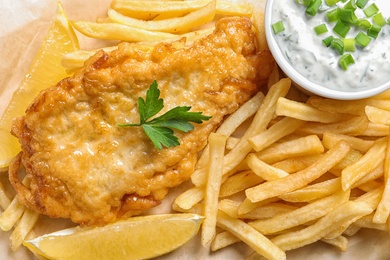 Photo of British traditional fish and potato chips, closeup