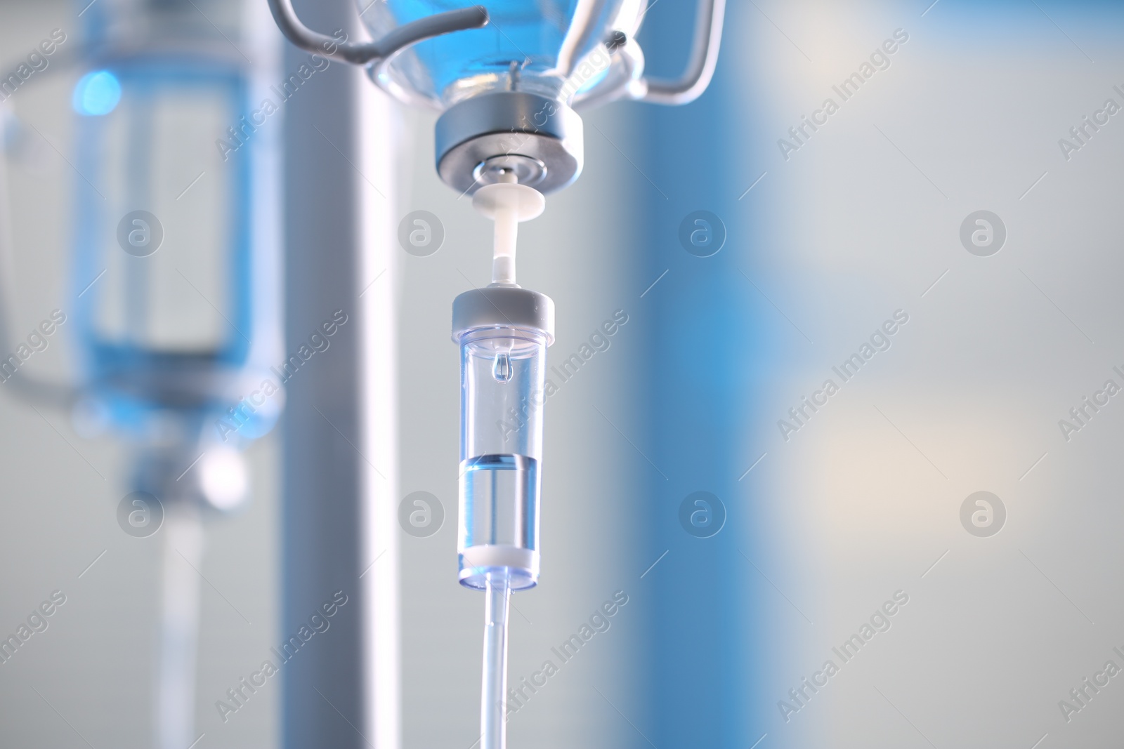 Photo of IV drip chamber against blurred light background