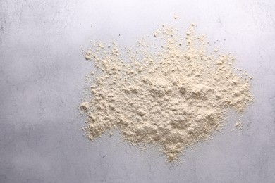 Photo of Pile of flour on light textured table, top view. Space for text