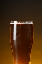 Glass with fresh beer against dark background, closeup