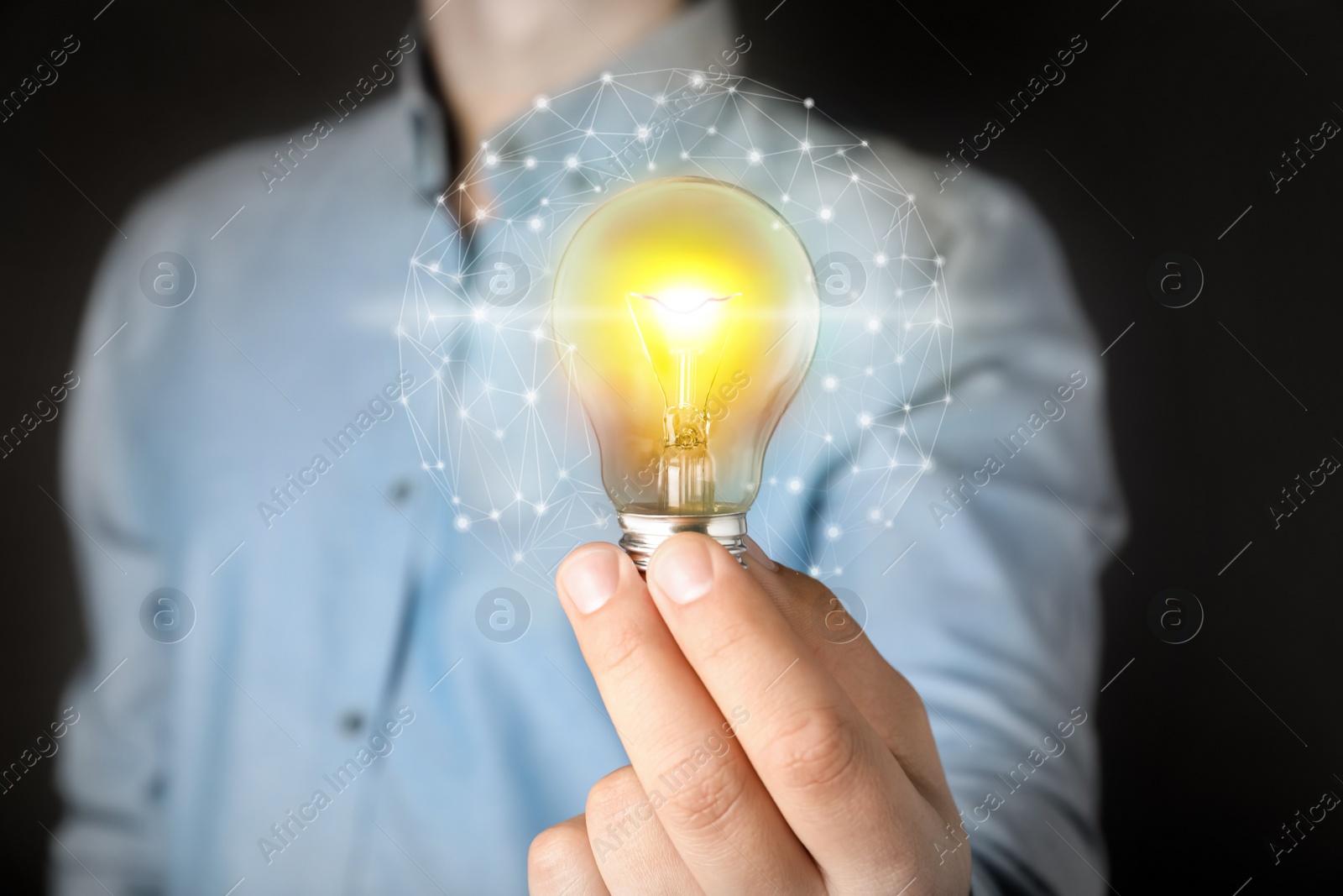 Image of Glow up your ideas. Man holding light bulb on dark background, closeup