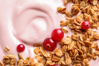 Photo of Tasty yogurt with cranberries and granola, closeup