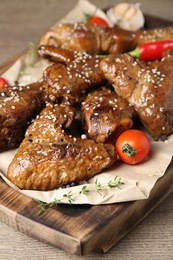 Tasty chicken glazed in soy sauce served on wooden table, closeup
