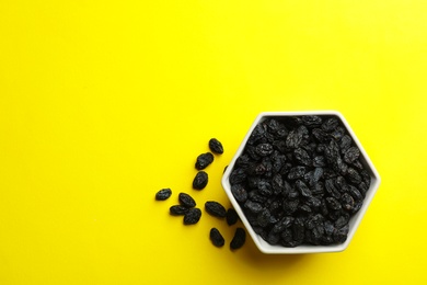 Photo of Bowl with raisins and space for text on color background, top view. Dried fruit as healthy snack