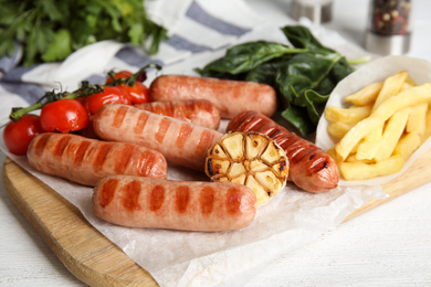 Photo of Delicious grilled sausages served on white table