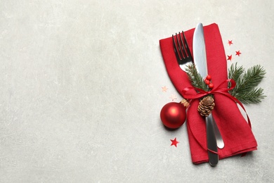Photo of Cutlery set and Christmas decor on light grey table, flat lay. Space for text