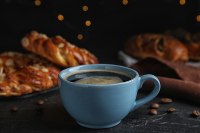 Delicious coffee and pastries on black table