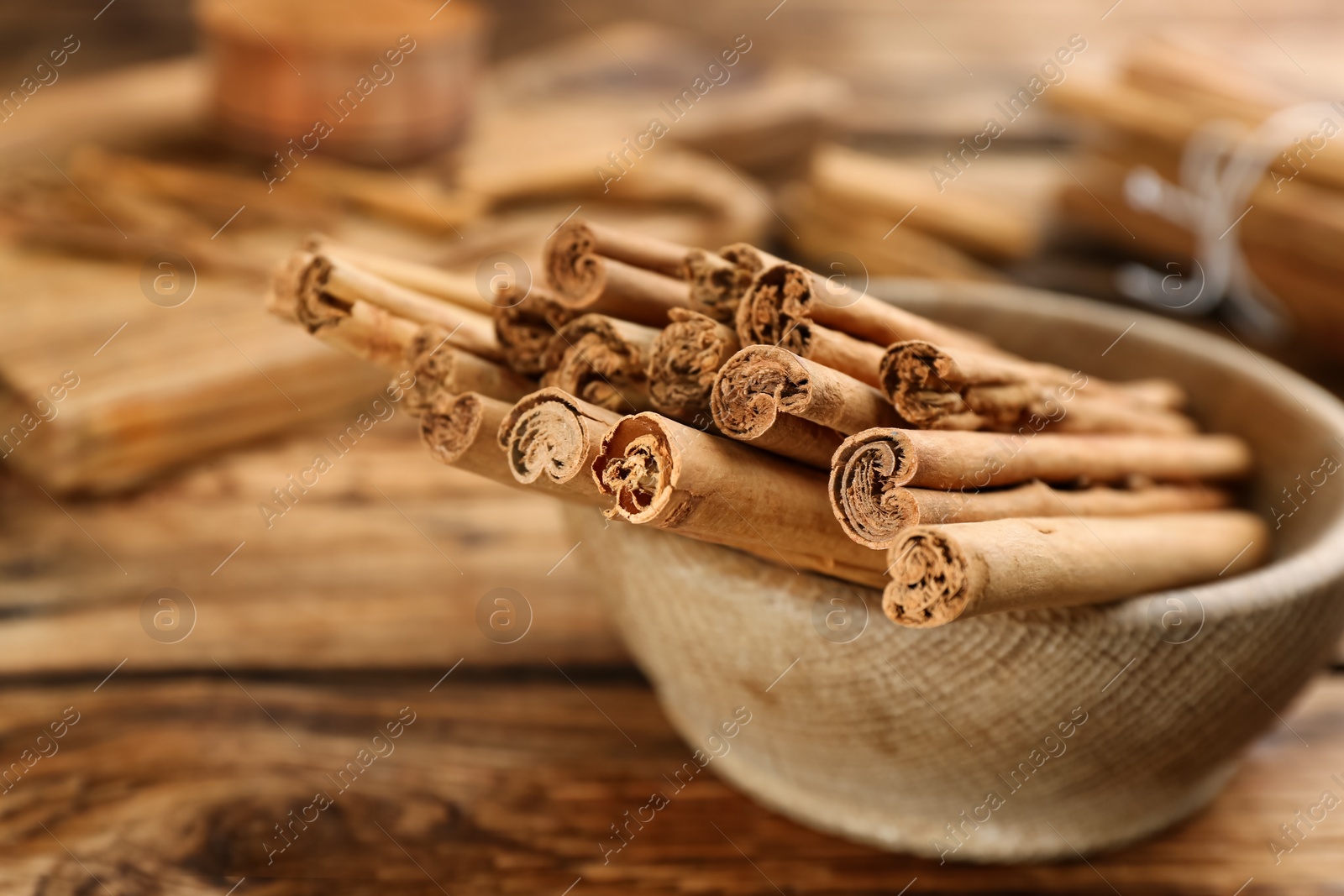 Photo of Aromatic cinnamon sticks on wooden table, closeup