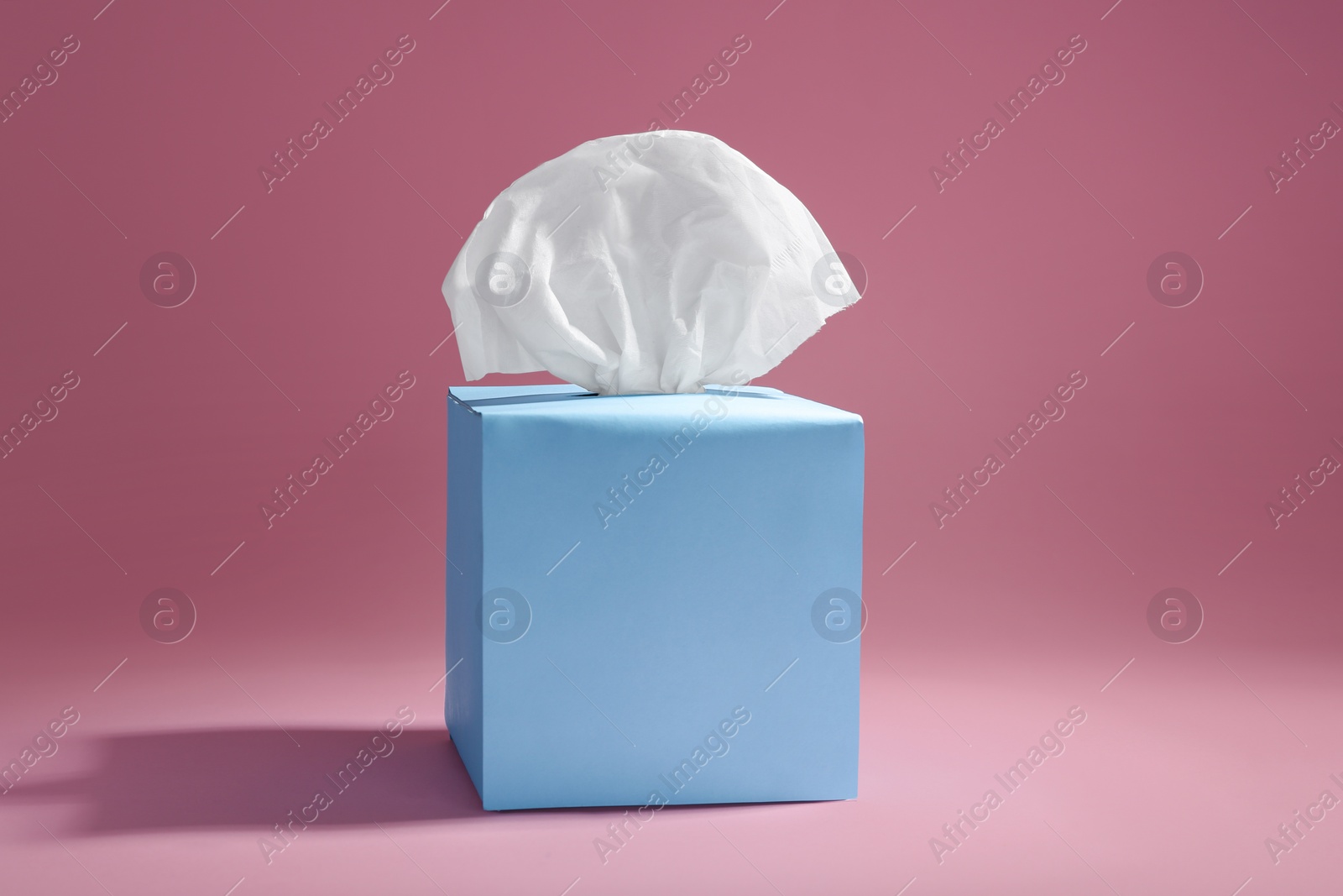 Photo of Box with paper tissues on pink background