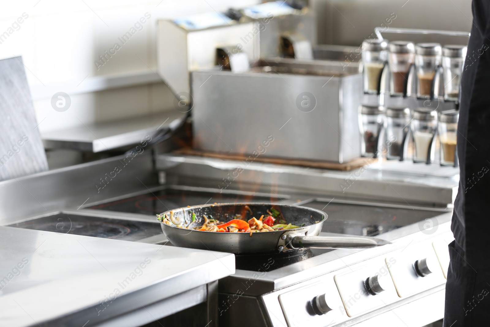 Photo of Cooking tasty food on stove in restaurant kitchen