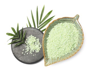 Photo of Green sea salt in bowl, spa stone and palm leaves isolated on white, top view