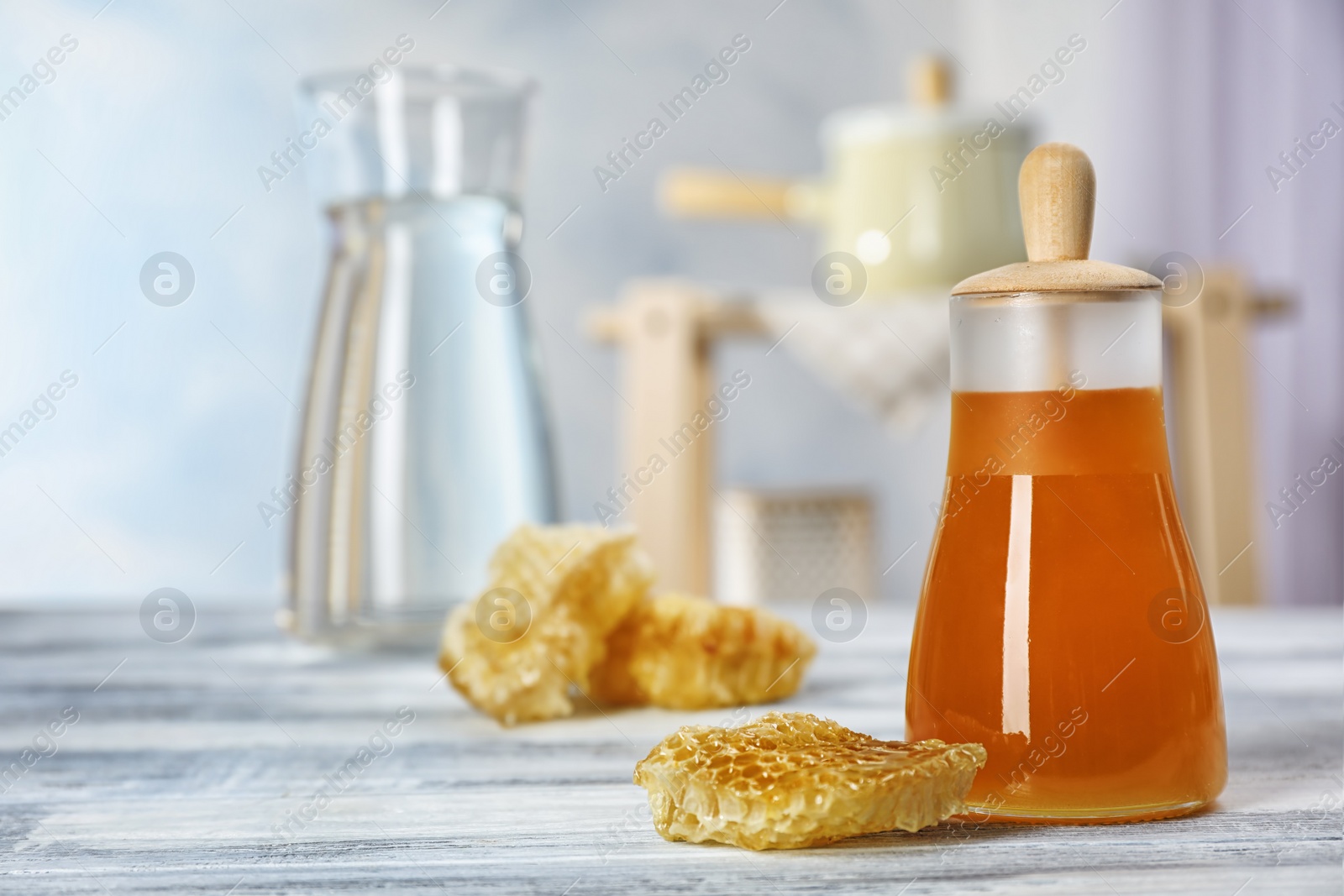 Photo of Jar of honey and honeycombs on table