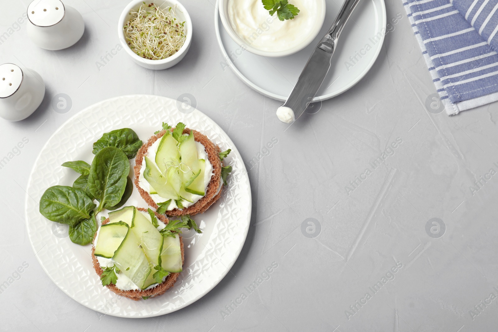 Photo of Flat lay composition with traditional English cucumber sandwiches on grey background. Space for text