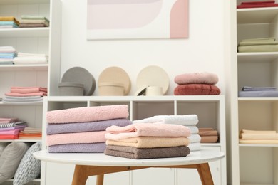 Photo of Stacked towels, decorative boxes and colorful bed linens in shop