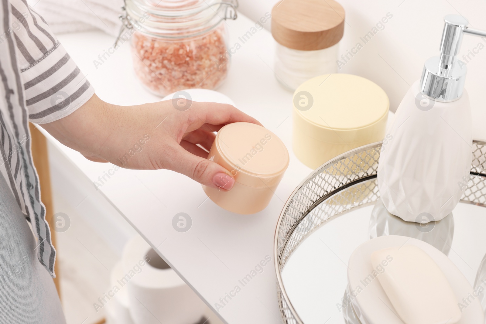 Photo of Bath accessories. Woman with jar of cosmetic product indoors, closeup