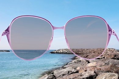 Image of Beach with stone breakwater on sunny day, view through sunglasses
