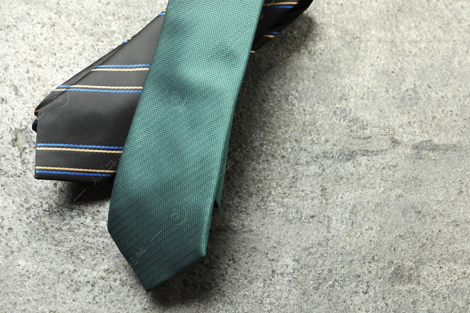 Photo of Two neckties on grey textured background, top view. Space for text