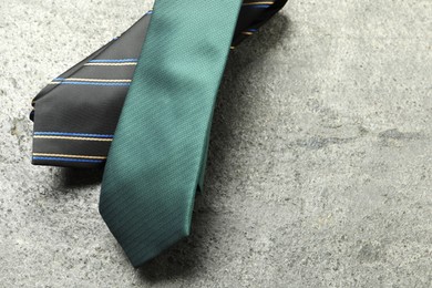 Photo of Two neckties on grey textured background, top view. Space for text