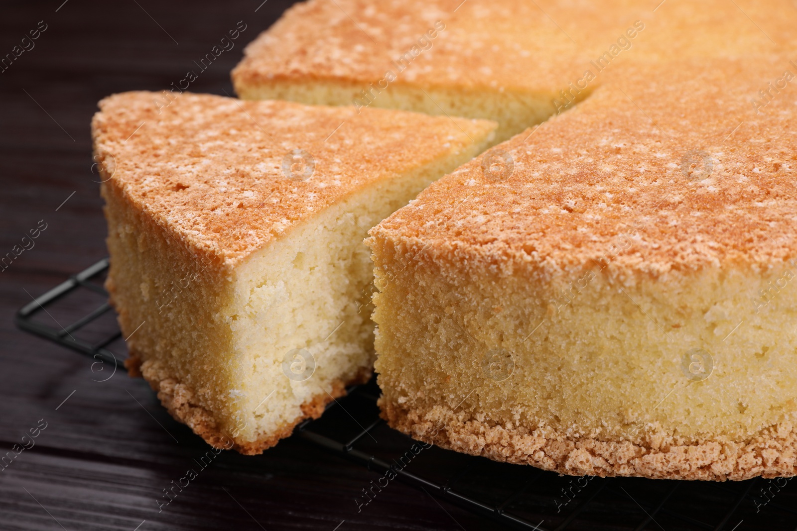 Photo of Tasty sponge cake on wooden table, closeup