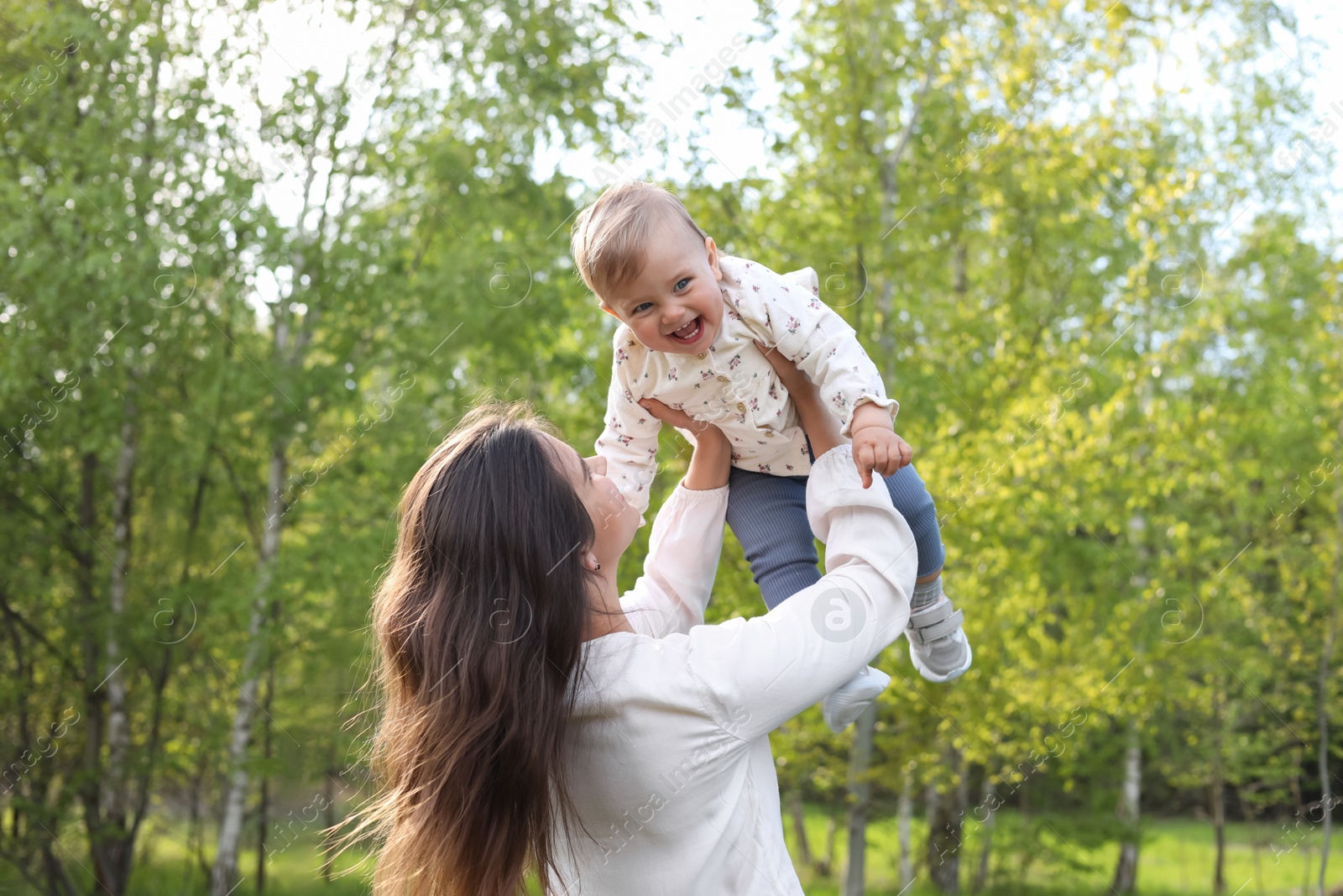 Photo of Happy mother playing with her cute baby in park on sunny day