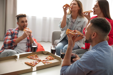 Photo of Group of friends eating tasty pizza at home
