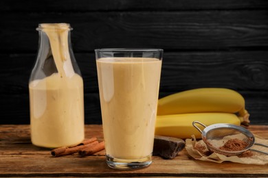 Tasty banana smoothie and ingredients on wooden table