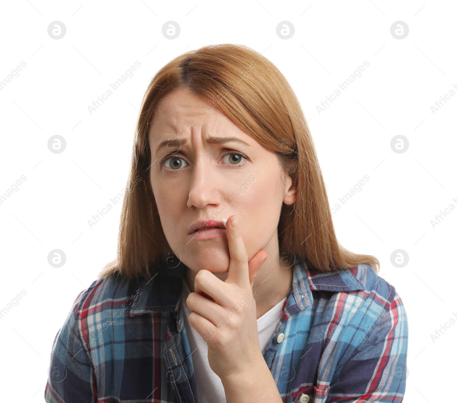 Photo of Upset woman with herpes applying cream on lips against white background