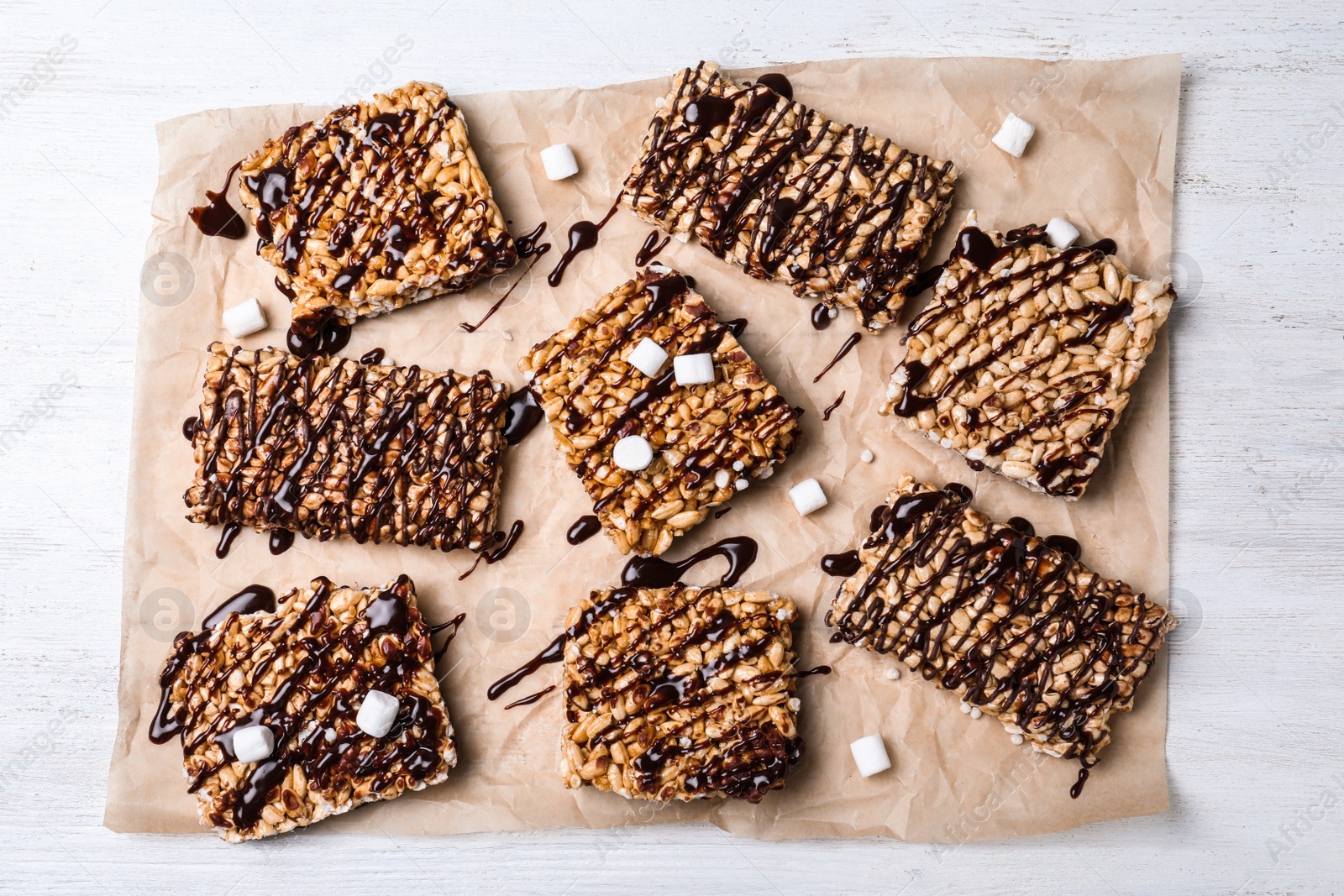 Photo of Delicious rice crispy treats on white wooden table, flat lay