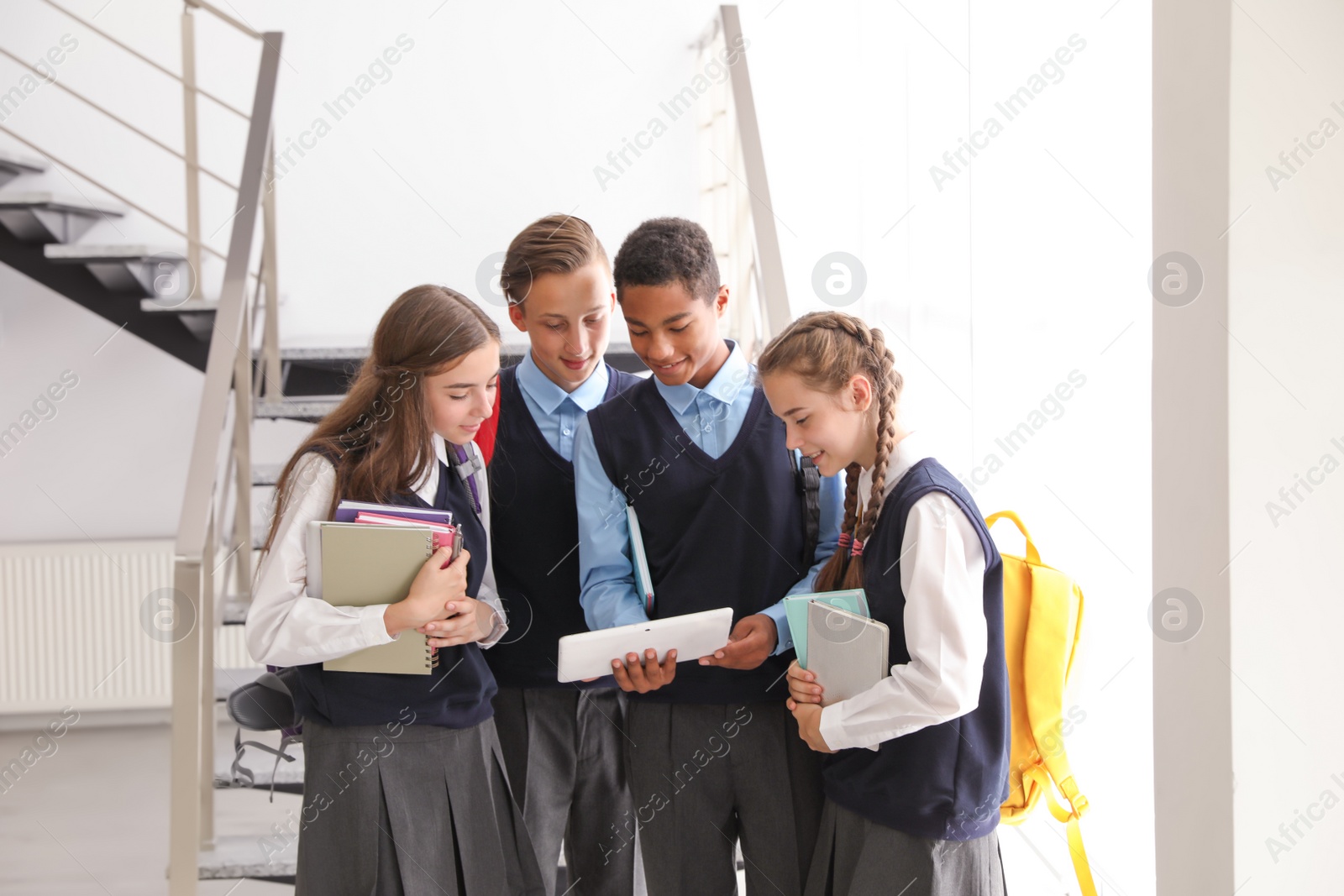 Photo of Teenage students in stylish school uniform indoors