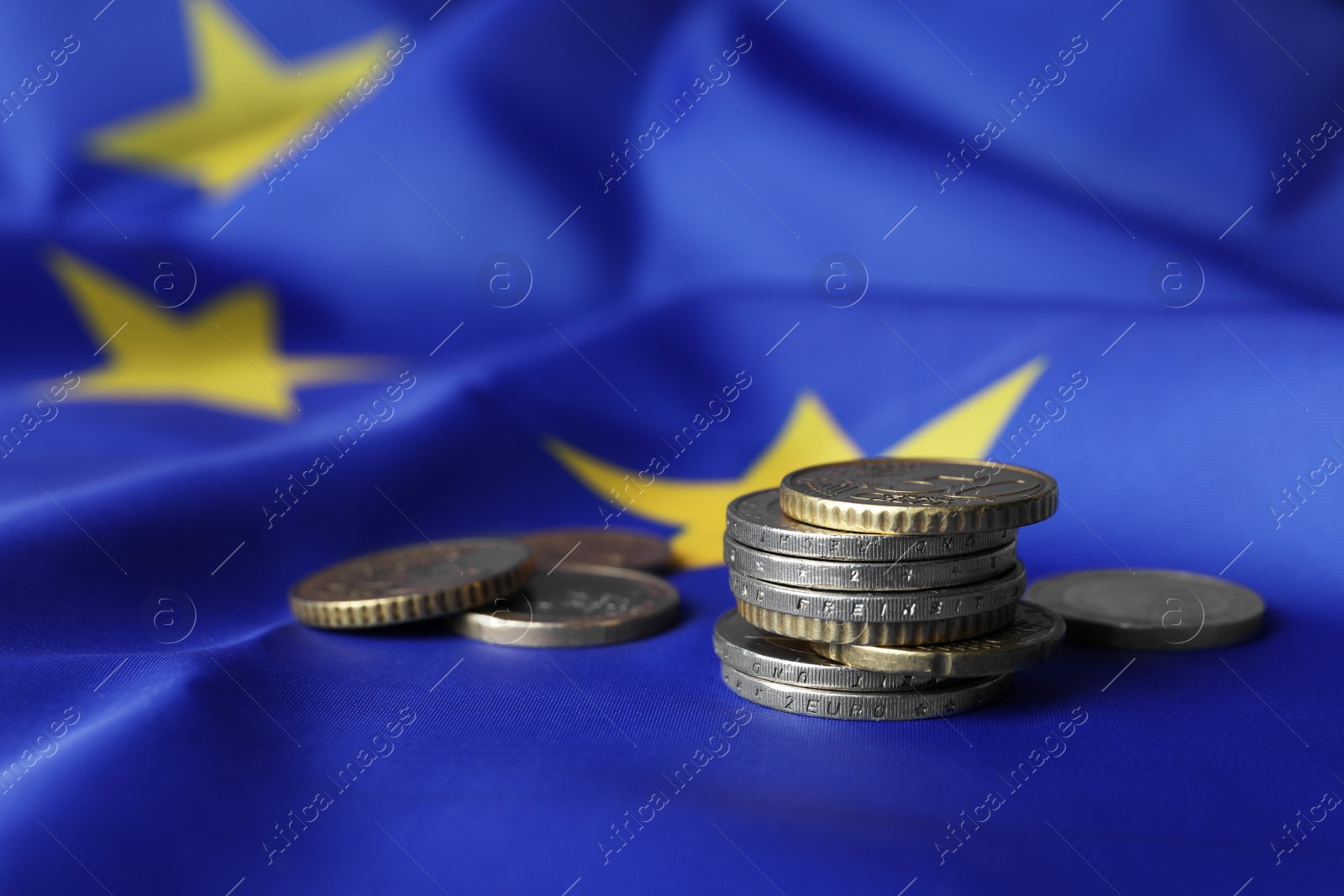 Photo of Many different coins on European Union flag, space for text