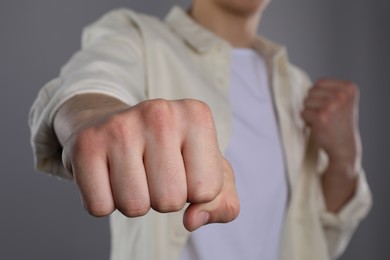 Man showing fist with space for tattoo on grey background, selective focus